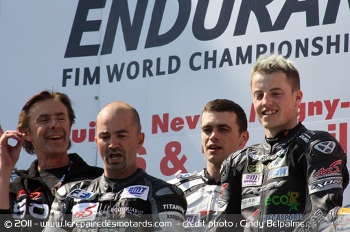 Hervé Moineau chantant la Marseillaise avec son team sur la première marche du podium